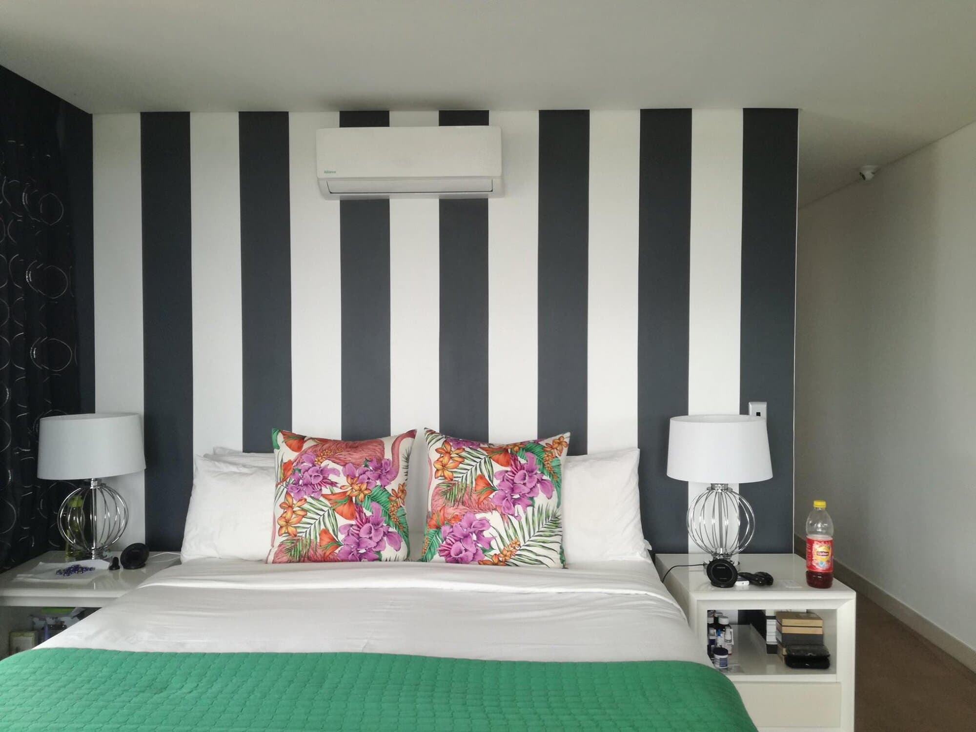 Bedroom renovation with a black and white striped feature wall behind the bed