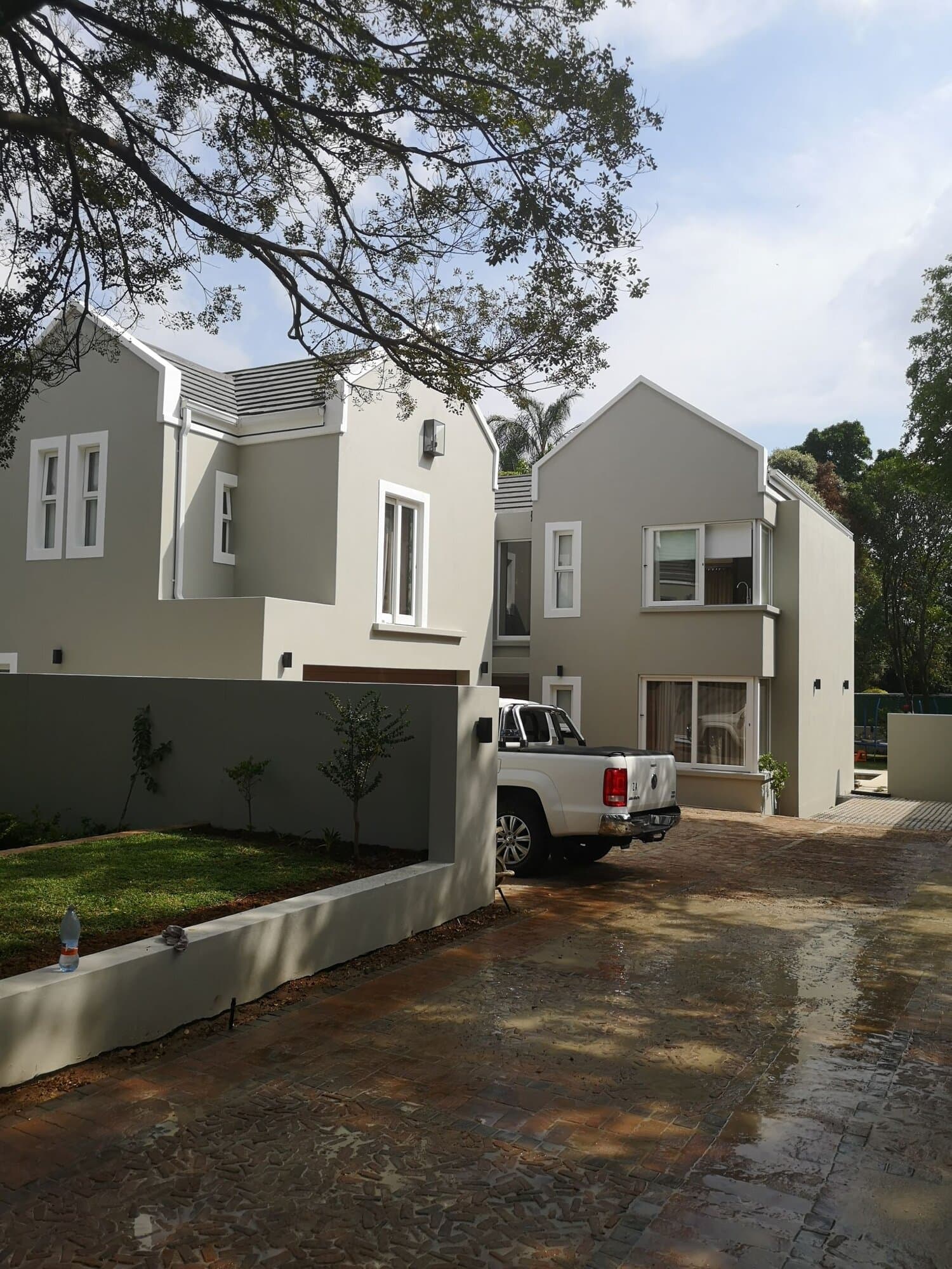 Freshly painted double-storey home exterior with grey render and white window trims