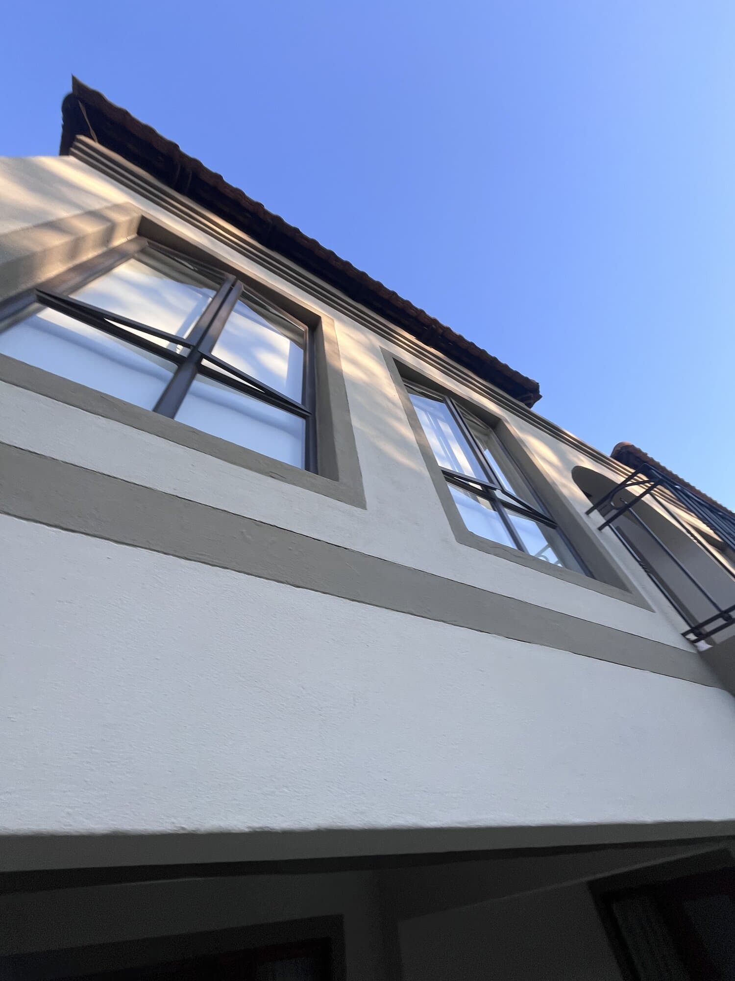 Close-up of freshly painted exterior windows and roofline on a renovated home