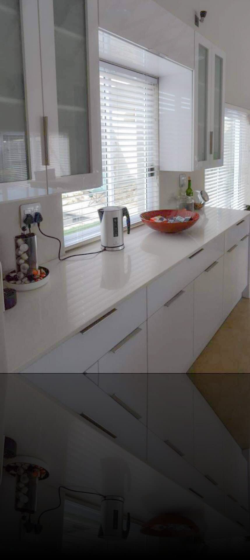 Kitchen renovation with white gloss cabinetry and a quartz countertop