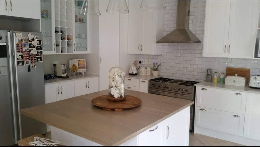 Kitchen renovation with a timber-top island, subway tile splashback and open shelving