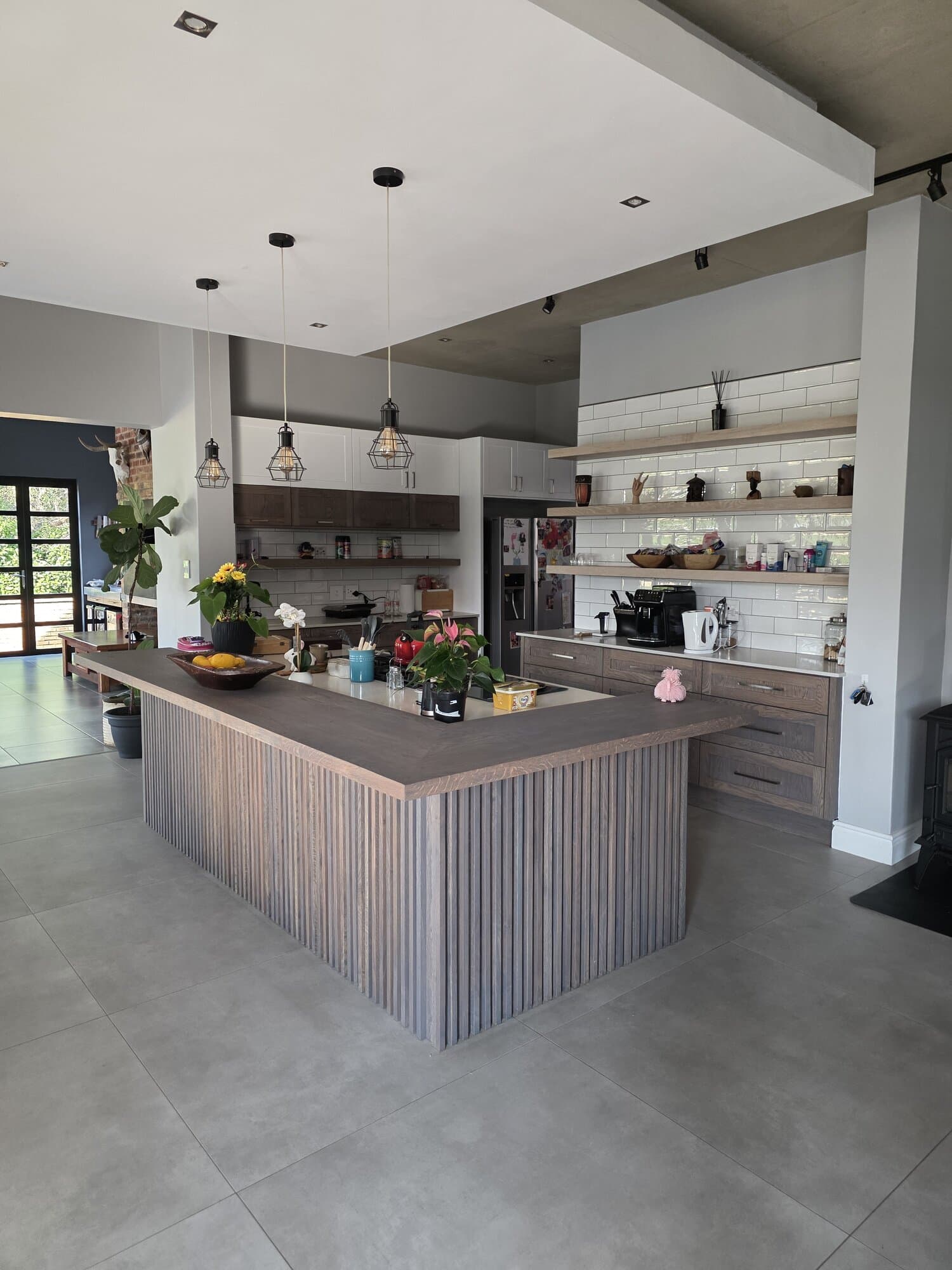 Kitchen renovation with a large island incorporating a built-in glass-fronted wine rack