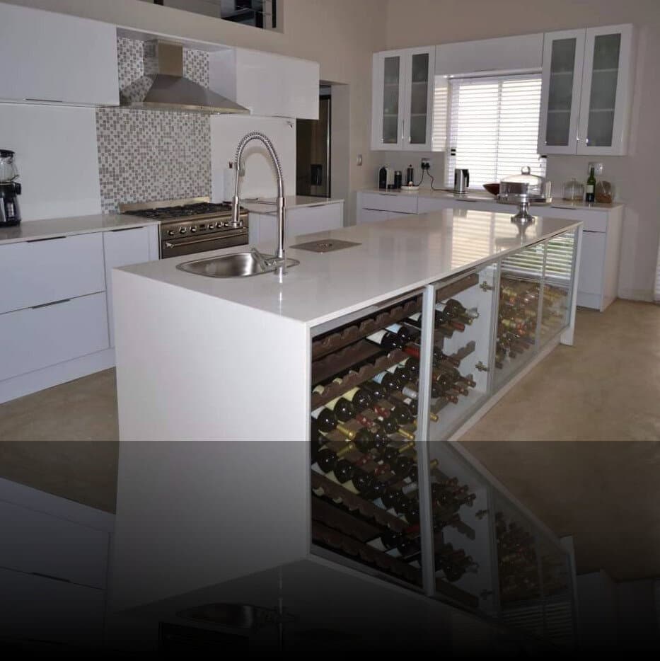 Kitchen renovation island with a built-in wine rack, gas stove and mosaic tile splashback