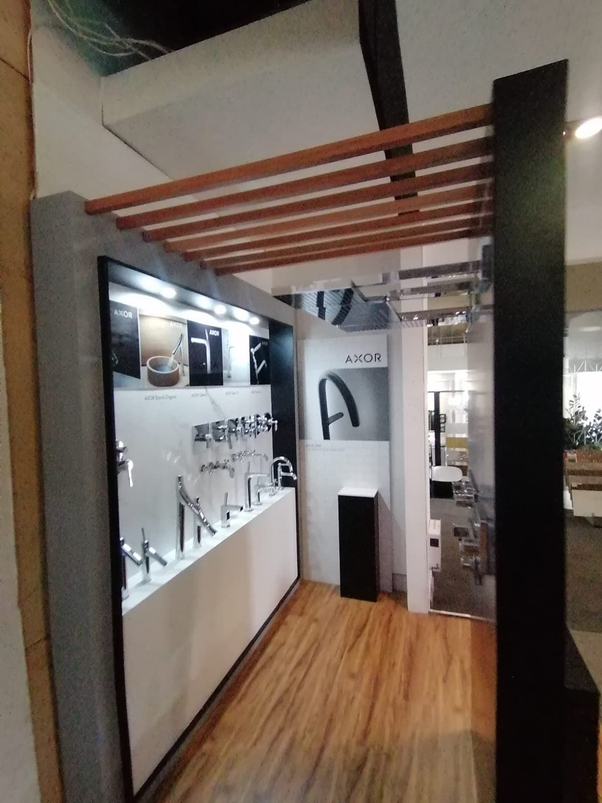 AXOR showroom fit-out with a freestanding display tower and wall-mounted tap displays