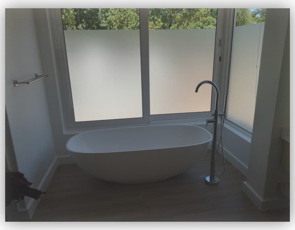 Bathroom renovation with a freestanding bath, floor-mounted mixer and frosted window
