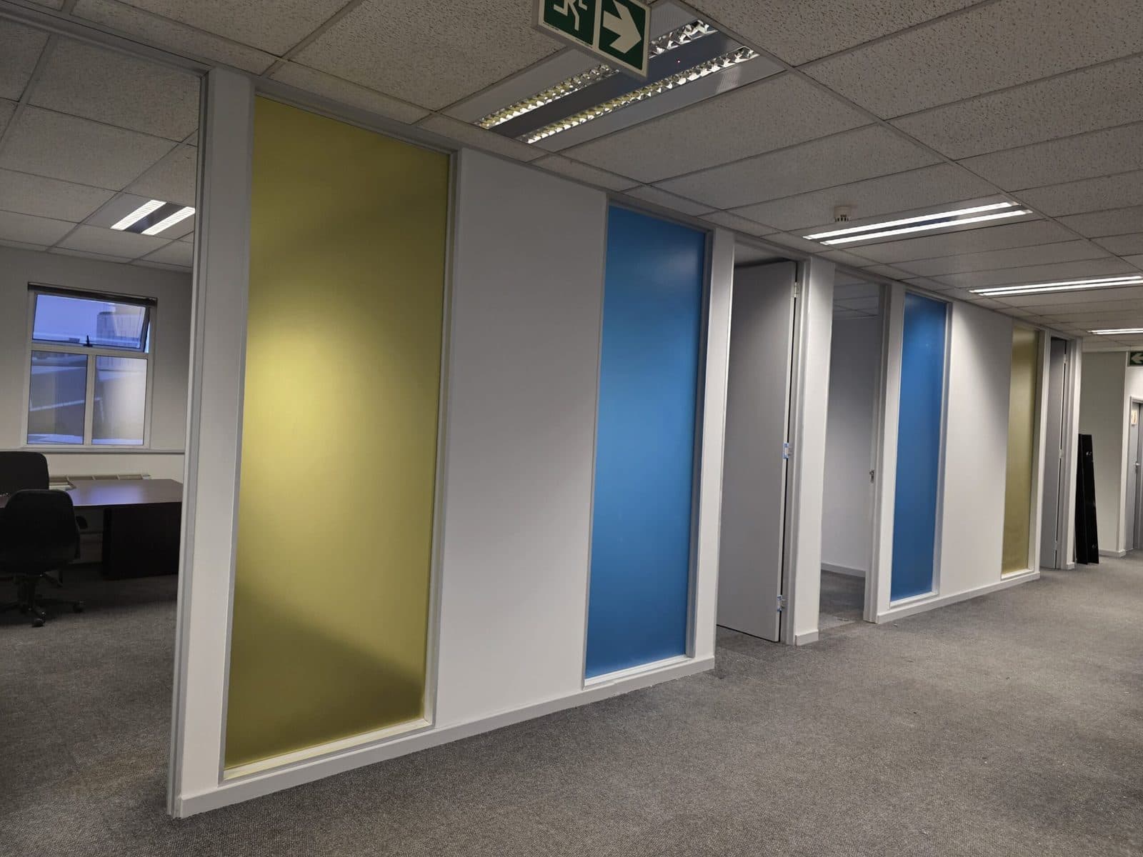 Office fit-out with partitioned meeting rooms and coloured glass panels